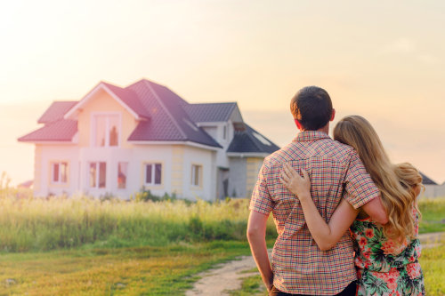 Homeowners Insurance in MN - A couple holding each other and looking at their home.