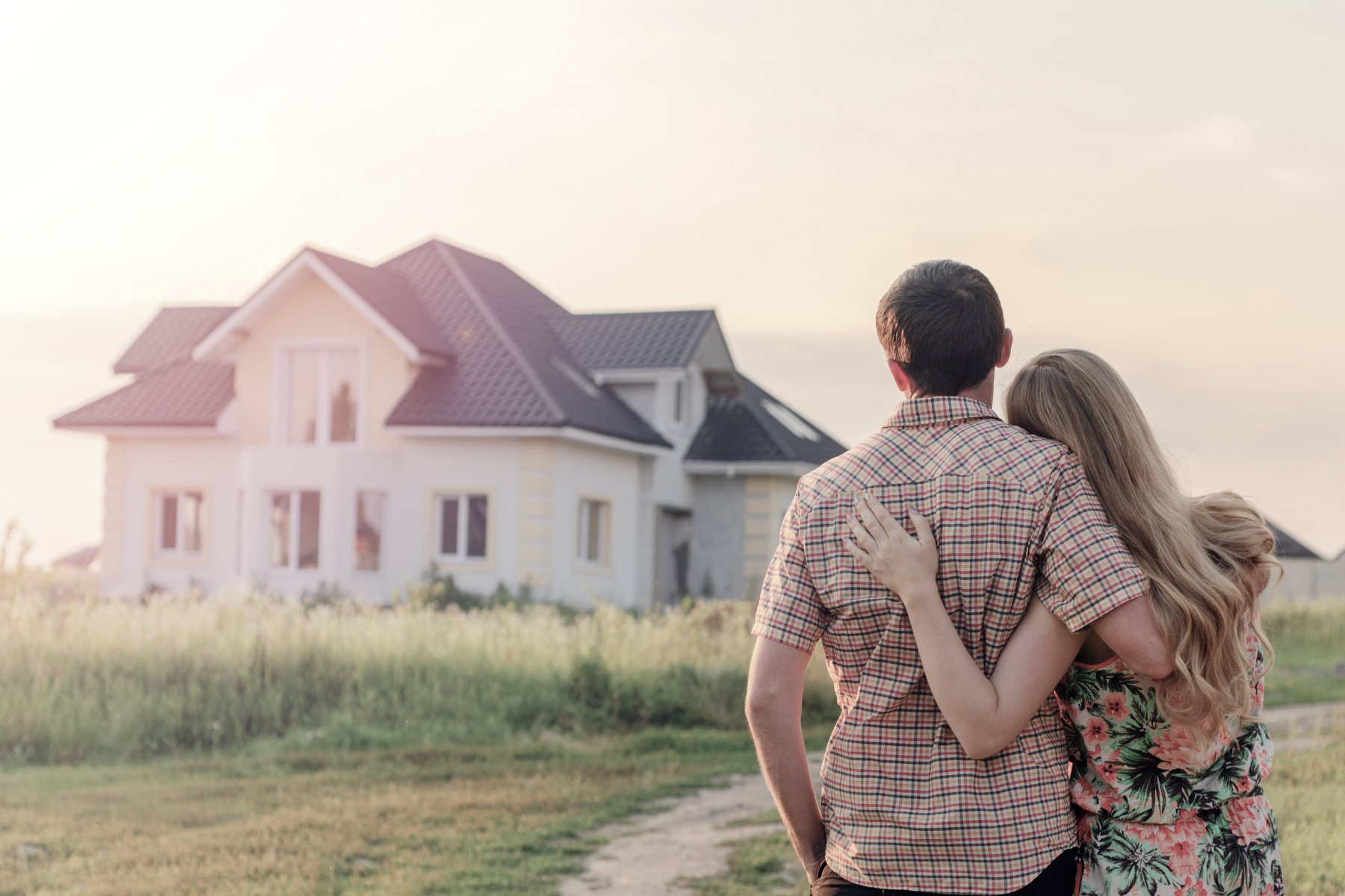 Homeowners Insurance - A couple holding each other and looking at their home.