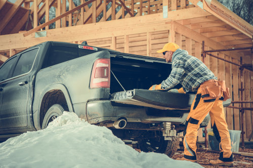 Commercial Auto Insurance in MN - A construction worker leaning on the open tail gate of a pickup truck