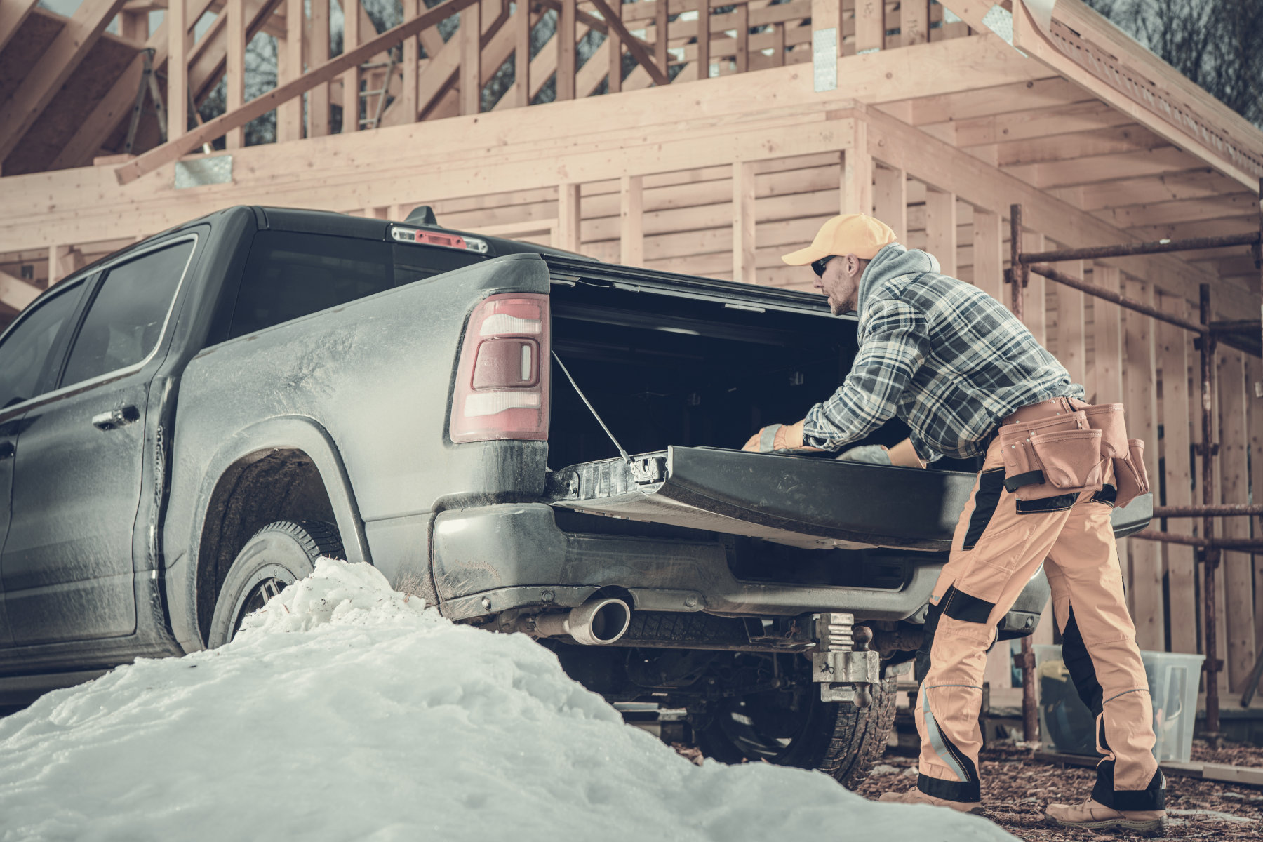 Commercial Auto Insurance - A construction worker leaning on the open tail gate of a pickup truck