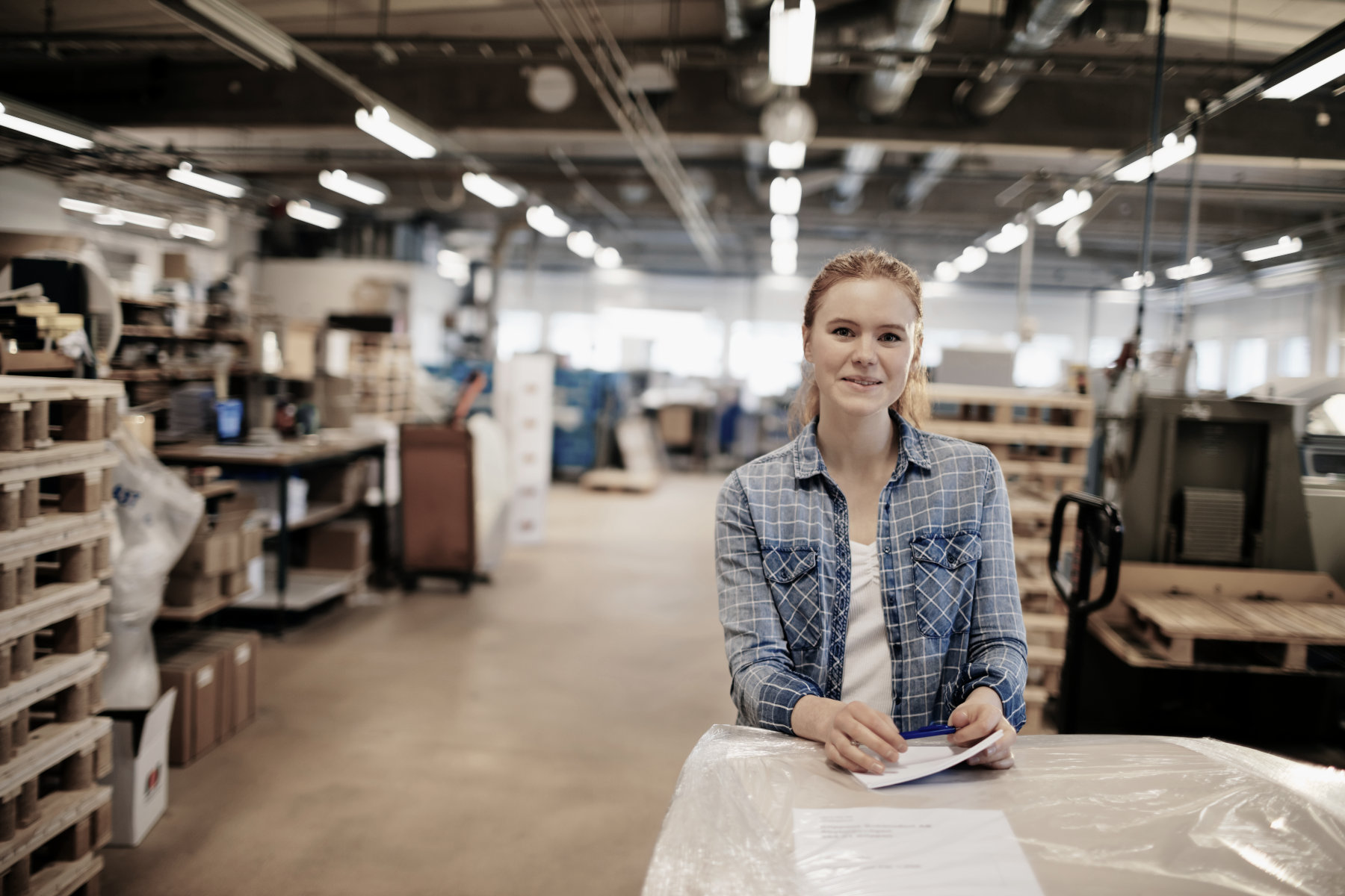 A young woman inside a warehouse.