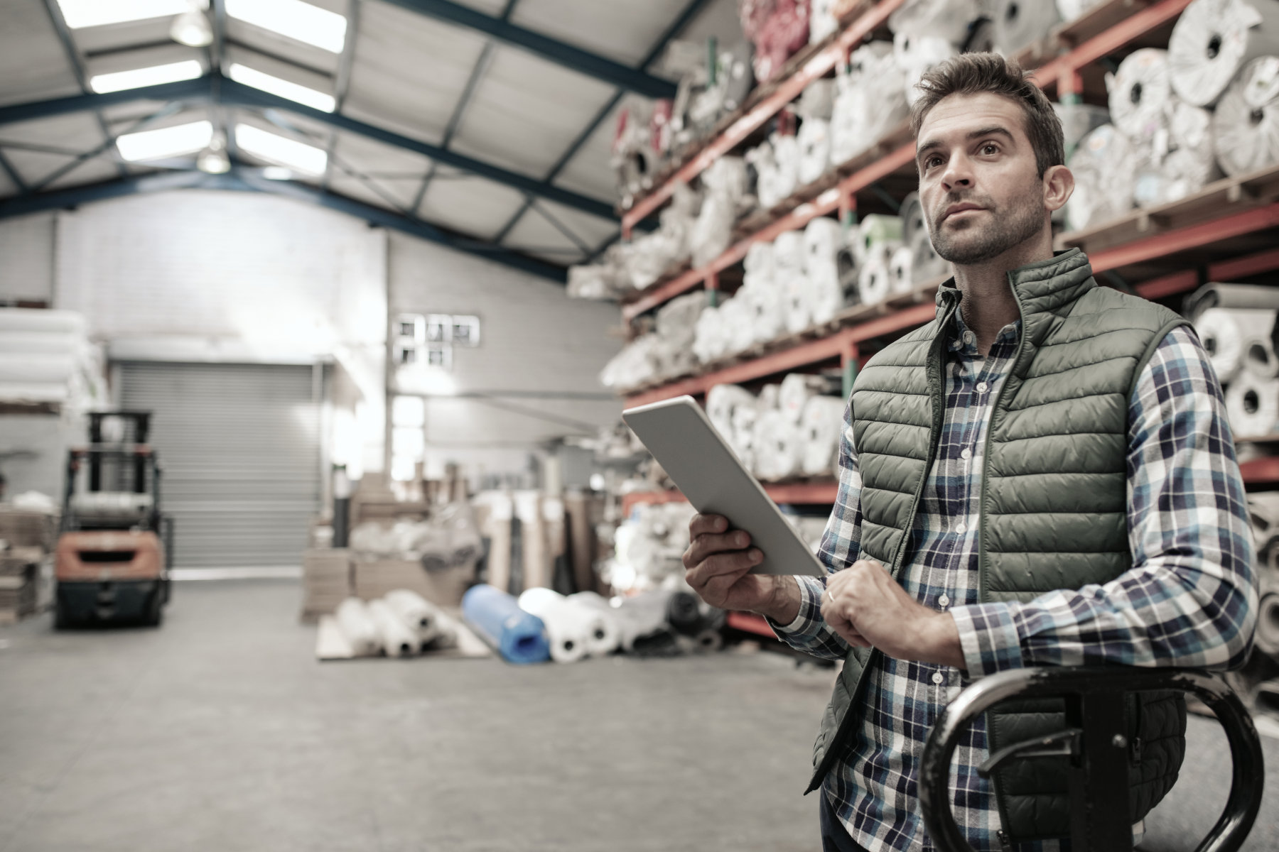 General Liability Insurance - A man in a warehouse holding a tablet computer.