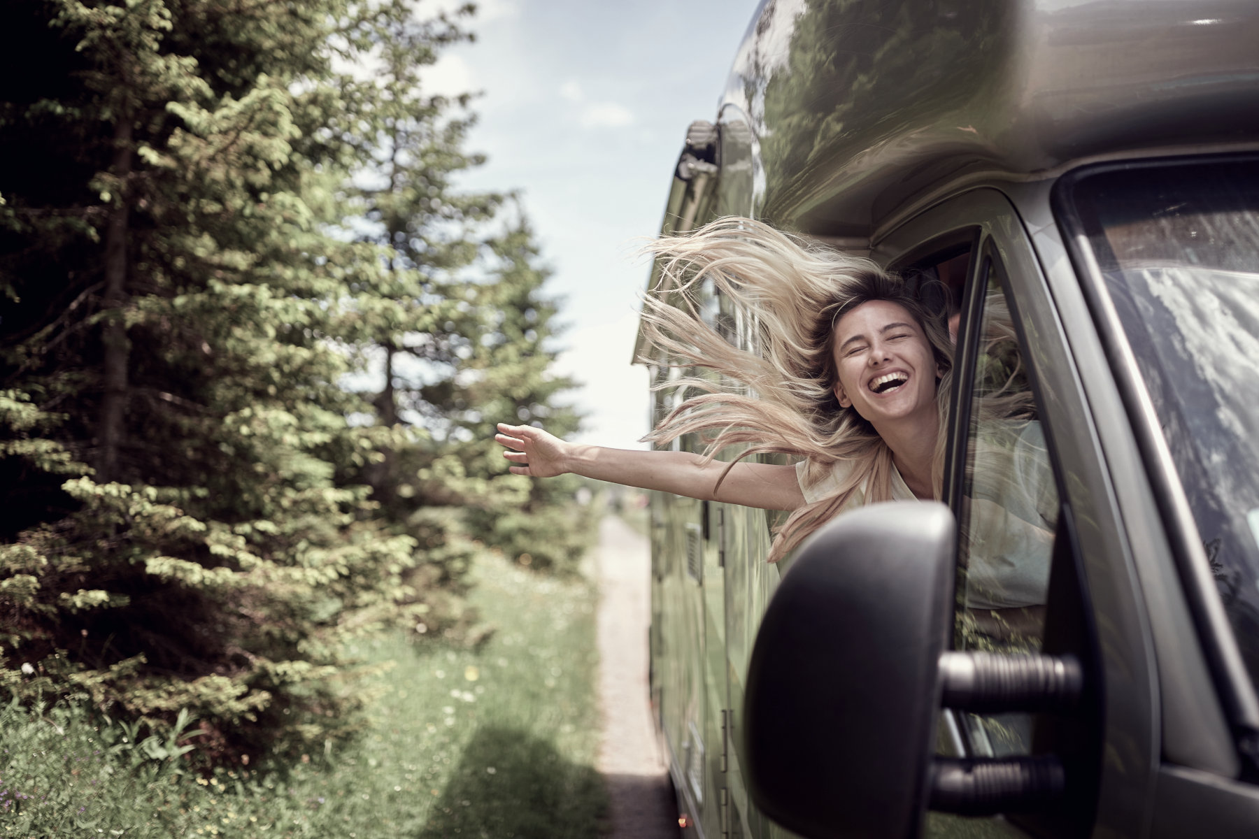 Recreational Insurance - A woman leaning out of the passenger window of an RV